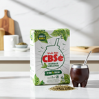 Product lifestyle shot of CBSé Hierbas Serranas Yerba Mate (1Kg) on a white marble table with a traditional cured gourd mate cup and a silver bombilla straw, illuminated by soft morning light.