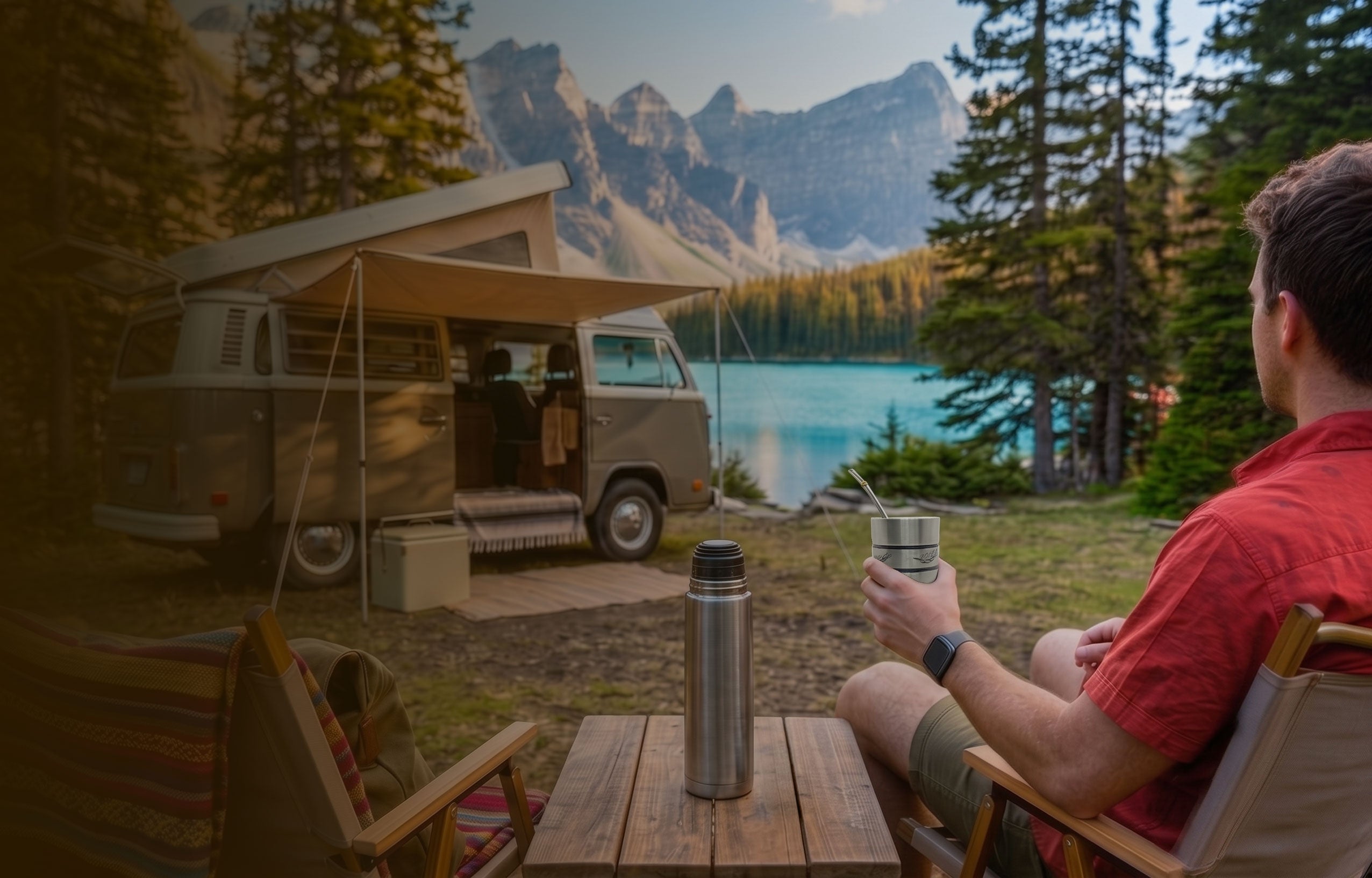 A man in a red shirt is sitting in a camp chair at a wooden table, enjoying a traditional mate (with a gourd and a bombilla). He is looking out at the stunning turquoise Moraine Lake and the towering, rocky peaks of the Canadian Rockies (Ten Peaks). On the table, a stainless steel thermos is placed. In the background, a vintage beige VW camper van with an open side door and a canvas awning extended is parked at the idyllic campsite, surrounded by pine forests.