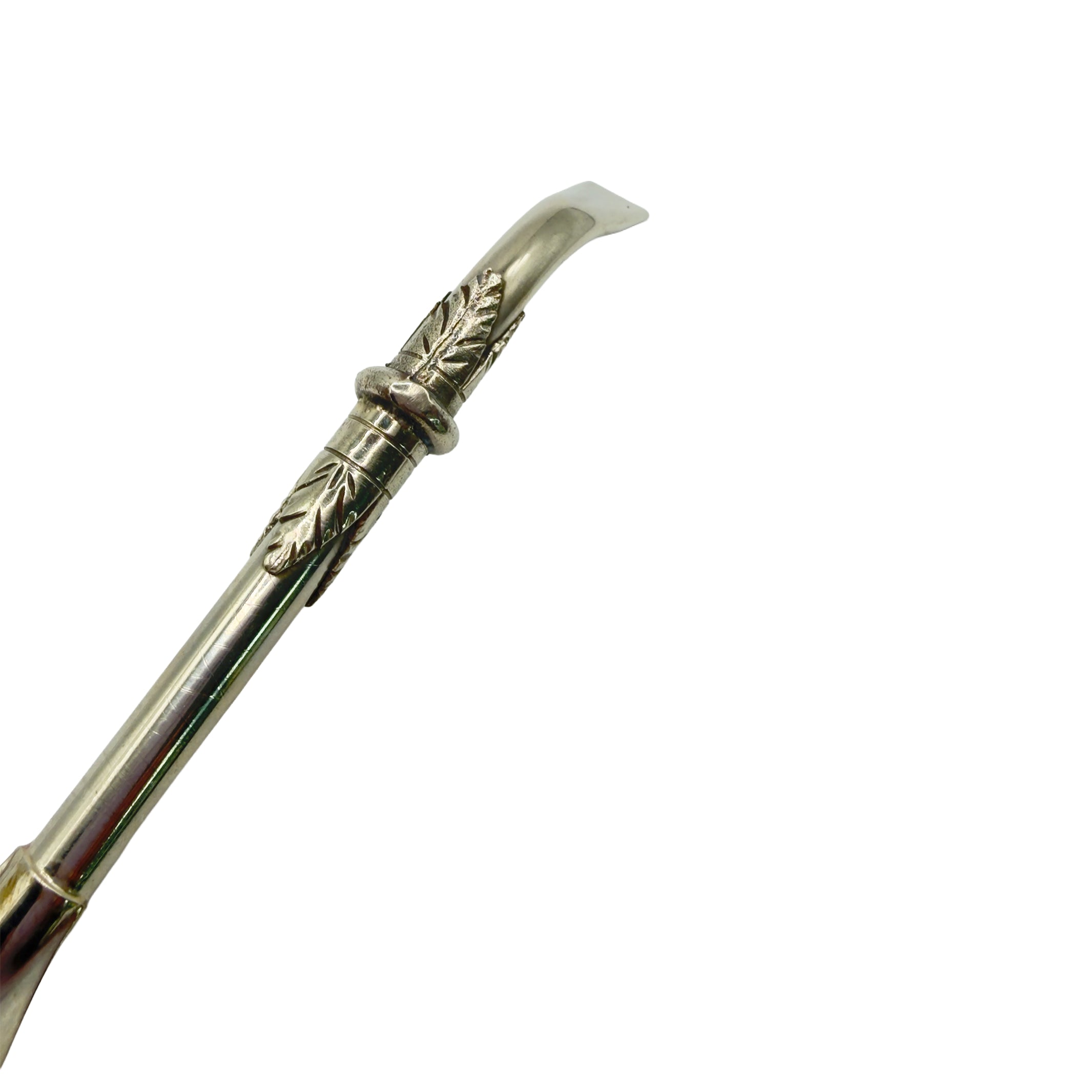 Close-up of the handcrafted leaf appliqué and curved stem on the Del Plata Alpaca Bombillón.