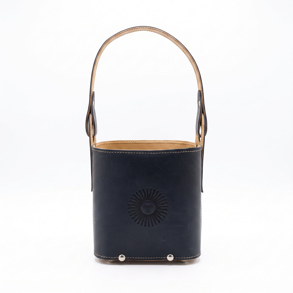 A black smooth leather Criolla Matera standing upright, featuring a top handle, fine contrast perimeter stitching, and an embossed Sun of May emblem on the front, set against a clean white background.