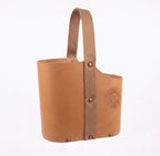 A light tan leather Uruguaya Matera featuring a matching beige woven nylon strap, brass-tone metal rivets, and an embossed Sun of May design on the front, set against a plain white background.