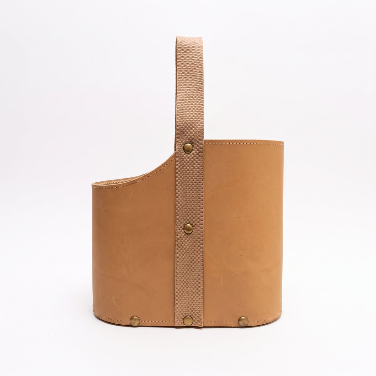 Side profile view of a light tan leather Uruguaya Matera featuring a vertical beige woven strap secured with brass-tone rivets, set against a plain white background.