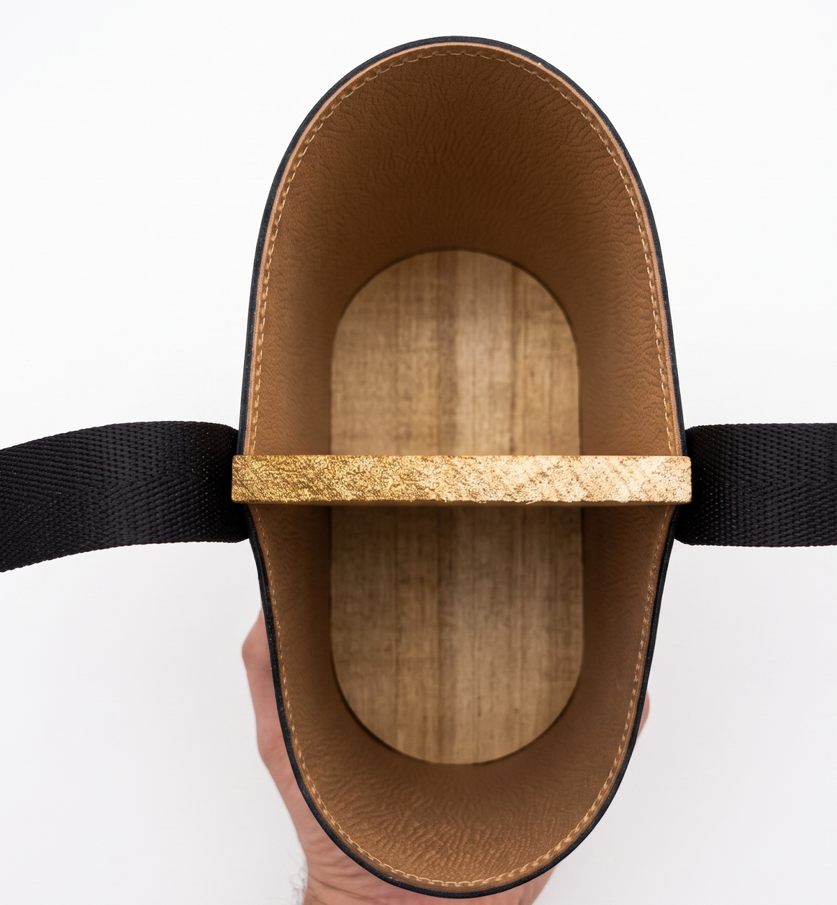 Top-down interior view of a black leather Uruguaya Matera, showing its textured tan leather lining, solid wooden base, central wooden divider, and black woven nylon straps against a white background.