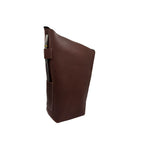 front and side perspective view. A closed, handcrafted leather yerbera in a rich reddish-brown Alazan color stands upright against a white background, highlighting its integrated side loop designed as a bombilla holder, with a metal bombilla inserted for display purposes only (bombilla sold separately).