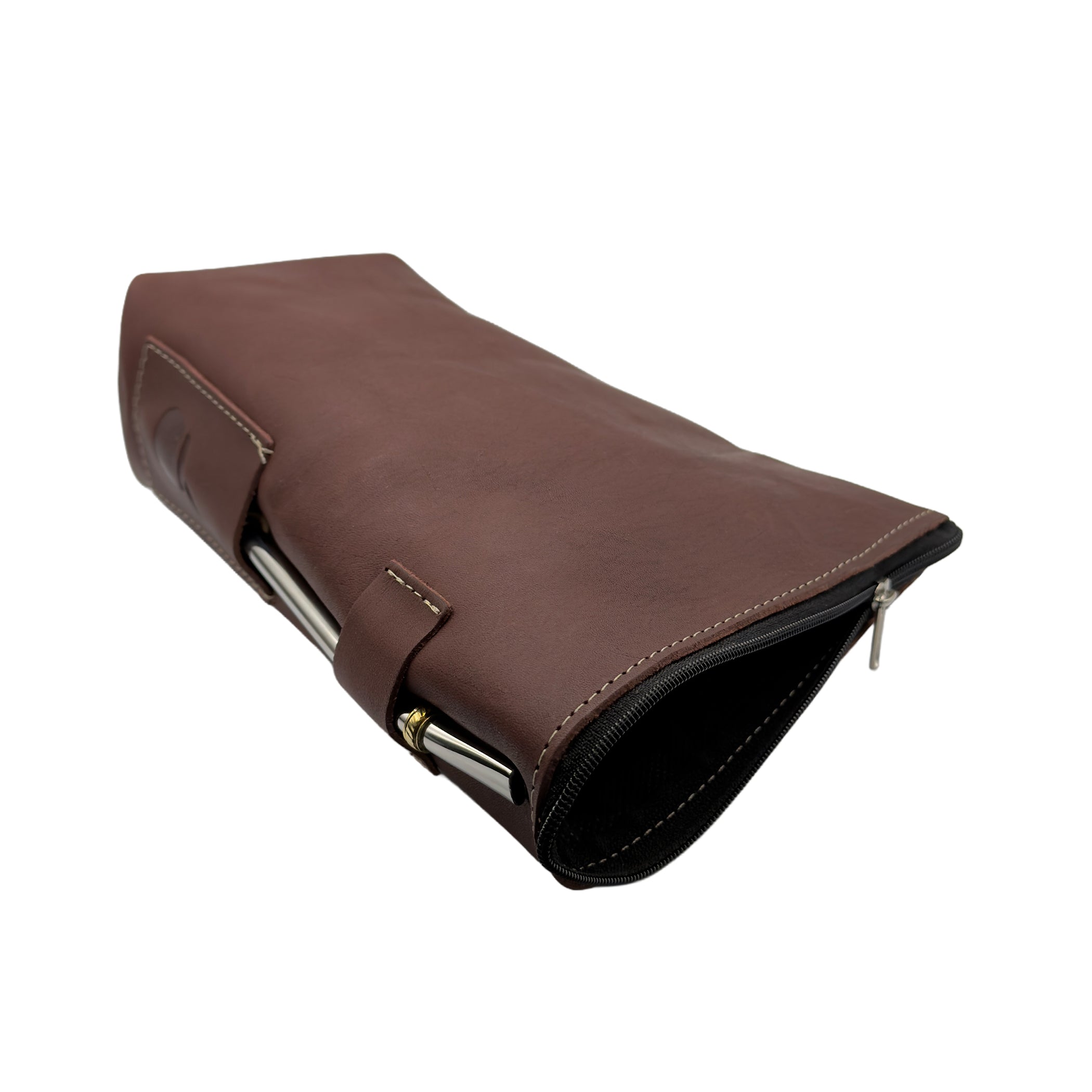 Top-down view. An open handcrafted leather yerbera in Alazan color lies horizontally with the top zipper open, revealing the dark interior storage compartment for yerba mate. A metal bombilla is held in the side loop, shown for display only (bombilla sold separately).