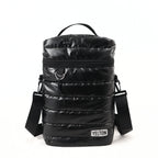 Front view of a black quilted puffer-style mate carrying bag by the brand YELTON against a plain white background. The image highlights the horizontal puff stitching, a top grab handle, a main zipper closure with a metal D-ring attachment, an adjustable black shoulder strap, and a white rectangular YELTON logo patch on the bottom right.
